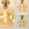 plafondlamp_goud_met_ambe_3.webp Clearance Straluma Plafondlamp goud met amber glazen bol 30 cm